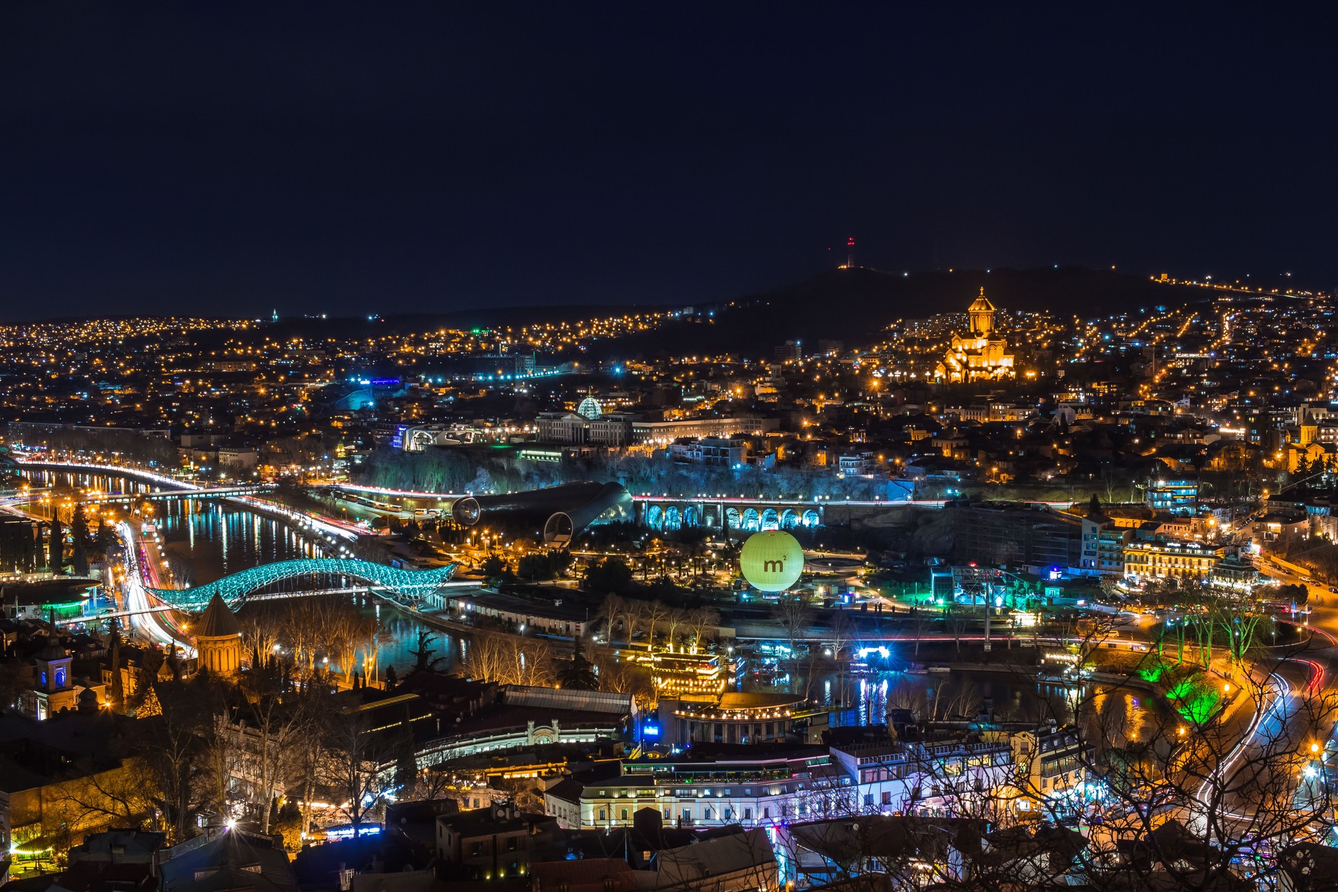 Night shot of Tbilisi with River Mtkvari ,illuminated Bridge of piece and Holy trinity church
